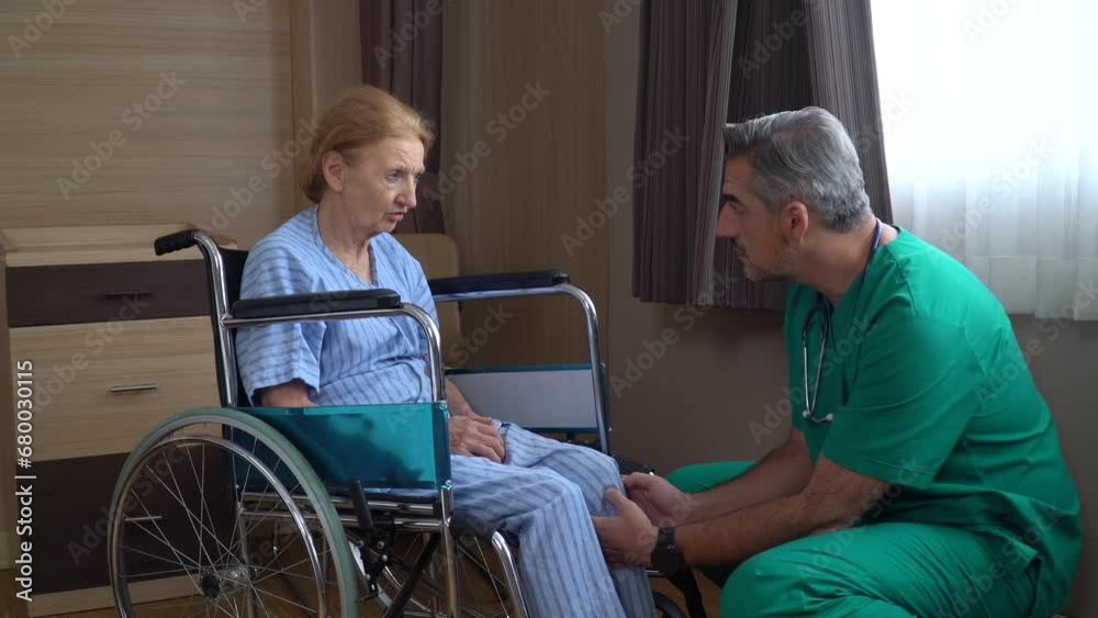 senior woman patient sit on wheelchair with doctor check-up knee and leg at hospital ward . old female talking to caregiver in Nursing home senior woman patient sit on wheelchair with doctor check-up knee and leg at hospital ward . old female talking to caregiver in Nursing home