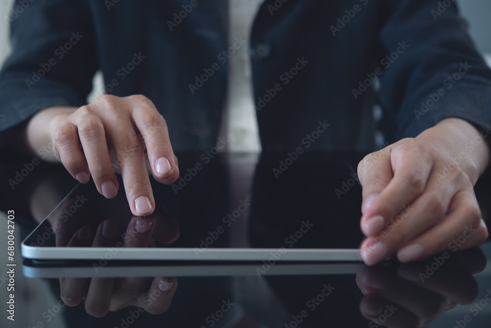 Close up of business woman using digital tablet, reading and proofing digital document on office table, front view