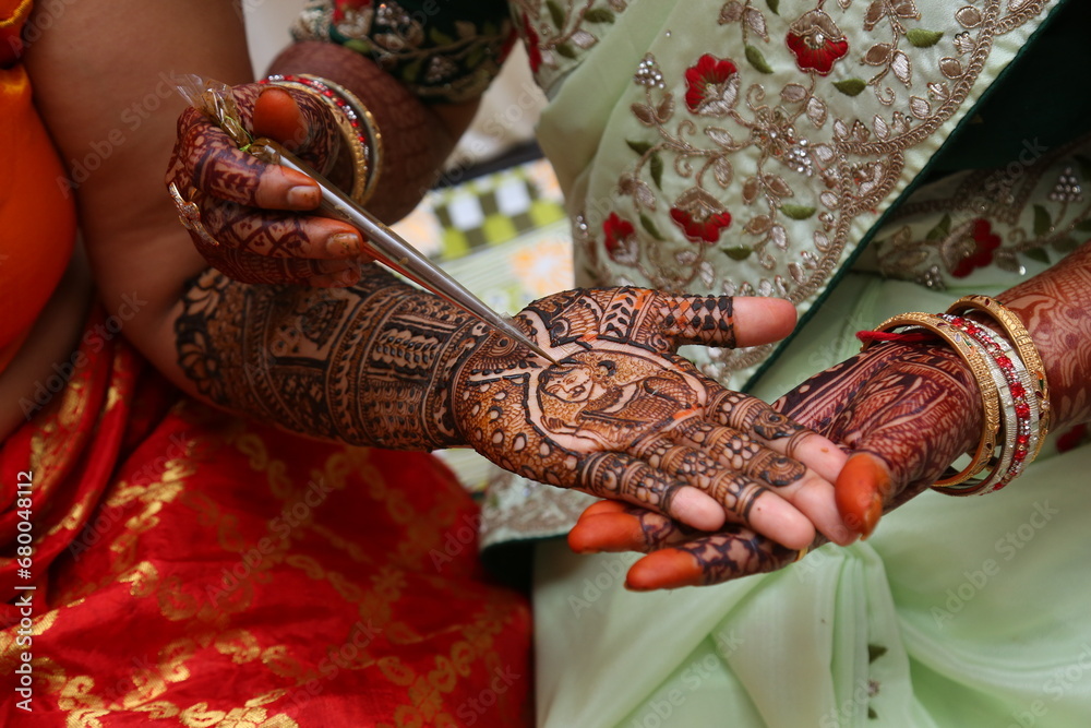 Indian bride getting mehendi designed on her hand