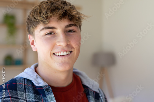 Portrait of happy caucasian male teenager with short blond hair at home photo
