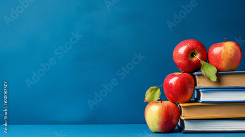 Textbooks with apples on the table on the background