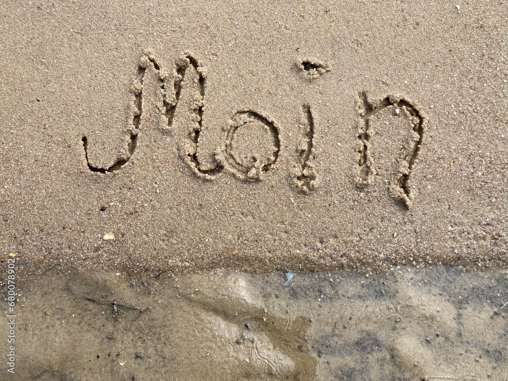 Fototapeta premium Moin als Gruß in den Sand geschrieben am Strand der Nordsee in Cuxhaven