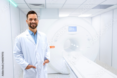 Portrait of smiling doctor radiologist standing inside hospital MRI diagnostic center.