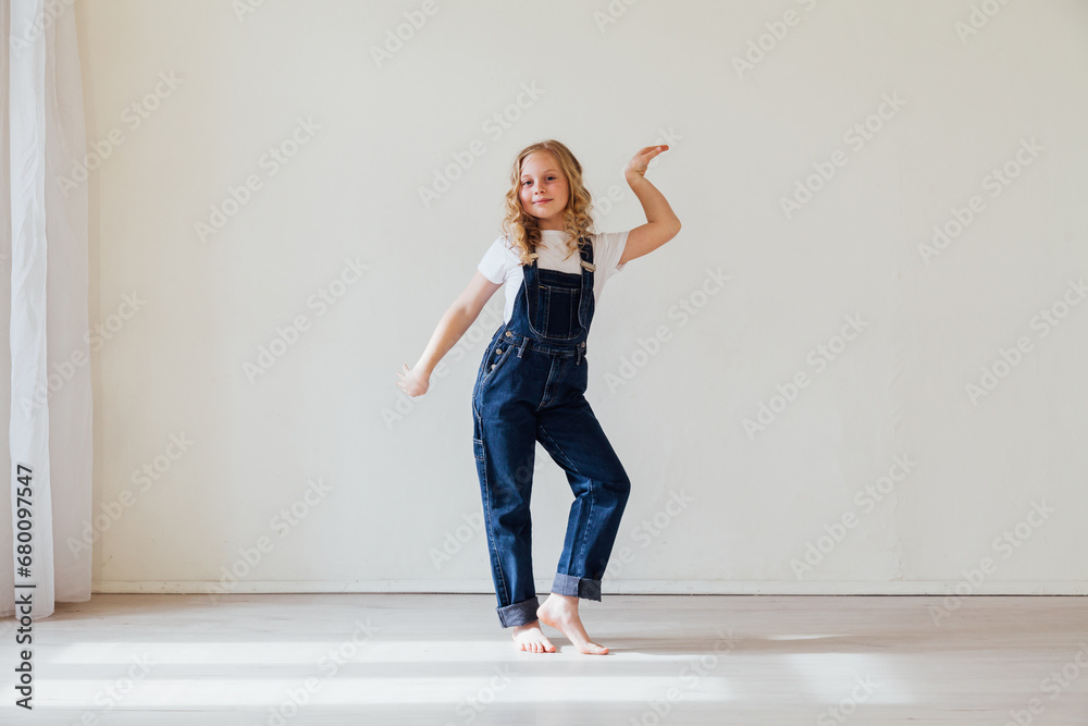 Girl in denim jumpsuit posing on light background