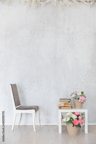 gray chair coffee table with books and flowers in a bright room