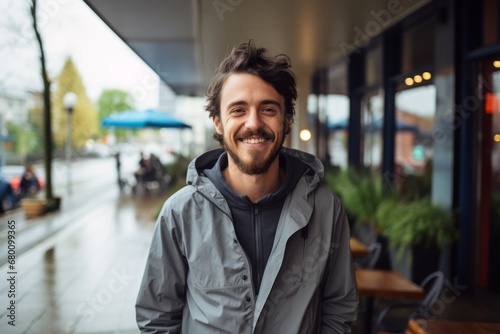 Portrait of a smiling man in his 30s wearing a functional windbreaker against a bustling city cafe. AI Generation