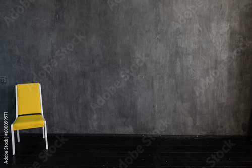 yellow chair on a gray background in a dark room interior minimalism