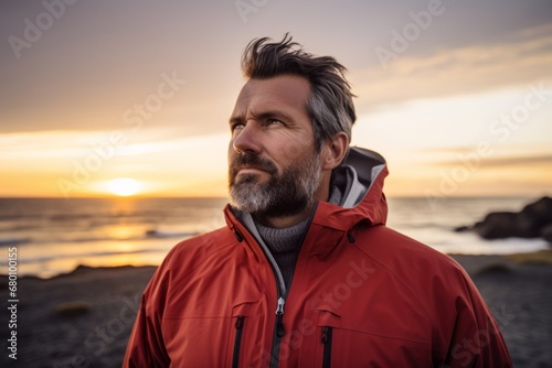 Portrait of a content man in his 40s wearing a windproof softshell against a beautiful beach sunset. AI Generation