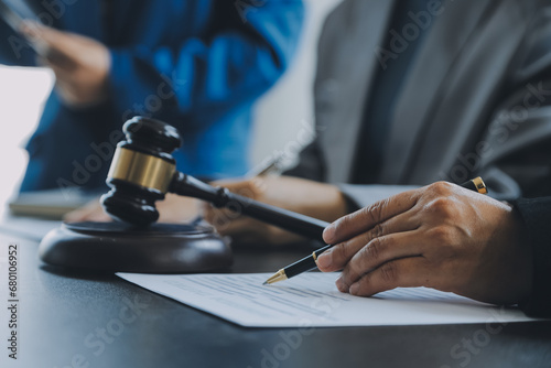 Business and lawyers discussing contract papers with brass scale on desk in office. Law, legal services, advice, justice and law concept picture with film grain effect