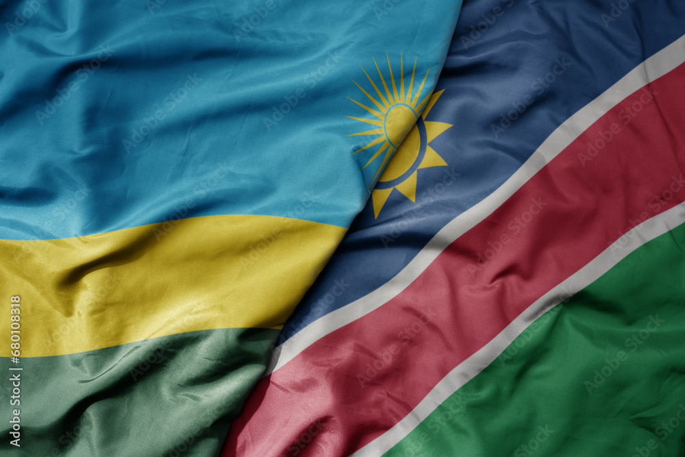 big waving national colorful flag of namibia and national flag of rwanda . big waving national colorful flag of namibia and national flag of rwanda .