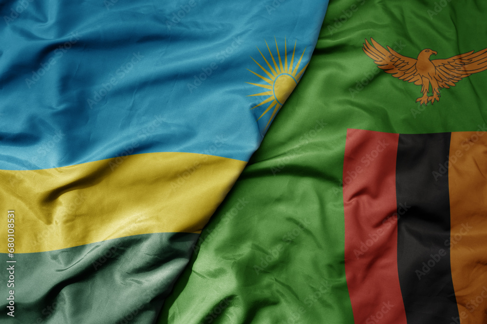 big waving national colorful flag of zambia and national flag of rwanda .