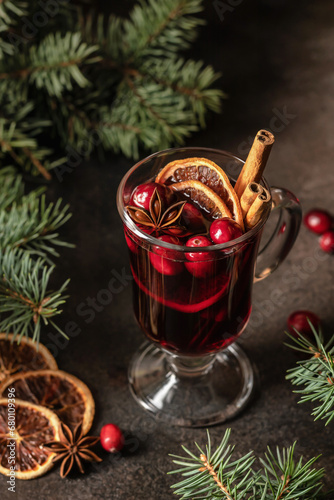 Christmas mulled red wine with spices and fruits on brown textured background. Traditional festive hot drink at Christmas time
