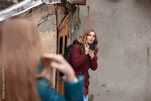 Young girl with professional camera taking photo of female client outdoor © Denys Kurbatov