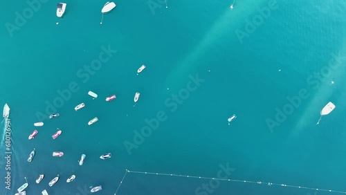 Steady overhead drone shot of boats and yachts in the blue sea of
