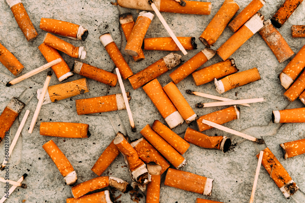 Cigarettes, matches and cigarette butts are scattered on the asphalt