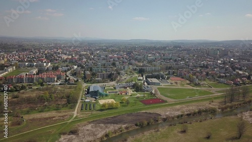 Panorama from a bird's eye view. Central Europe: The Polish village is located among the green hills and river. Temperate climate. Flight drones or quadrocopter. Urbanization of the landscape.