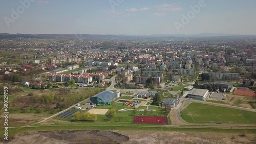 Panorama from a bird's eye view. Central Europe: The Polish village is located among the green hills and river. Temperate climate. Flight drones or quadrocopter. Urbanization of the landscape.