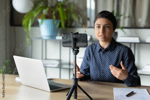 Cuadro en lienzo Serious Indian presenter girl, speaker talking at webcam on smartphone