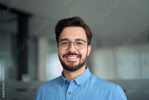 Smiling happy young latin business man bank manager, adult professional businessman executive in office, male entrepreneur, software developer or company employee wearing glasses, headshot portrait.