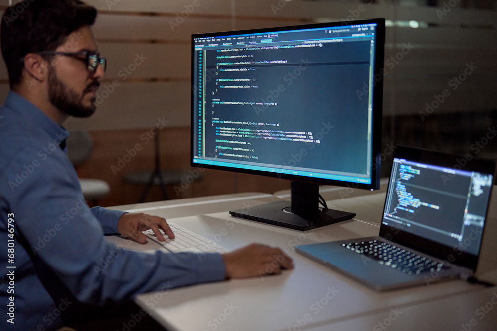 Software developer engineer it programmer working late on desktop pc computer in dark night office. Coder developing code with ai software development technology solutions on multiple screens. Software developer engineer it programmer working late on desktop pc computer in dark night office. Coder developing code with ai software development technology solutions on multiple screens.