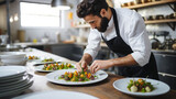 Male chef plating food in plate while working in commercial kitchen