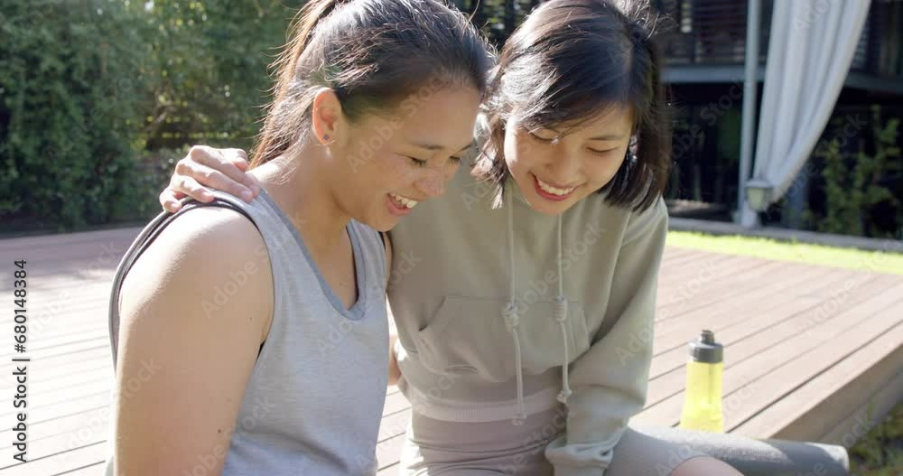 Happy asian female friends with water bottle doing selfie and smiling on terrace, slow motion Happy asian female friends with water bottle doing selfie and smiling on terrace, slow motion