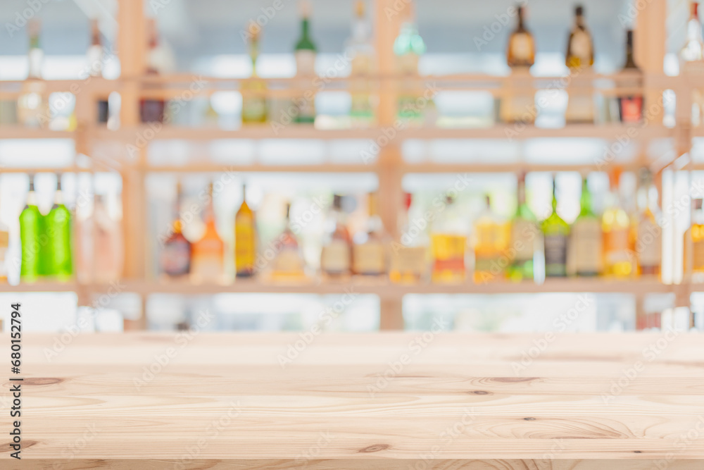 blur cocktail pub restaurant wooden counter bar with alcohol bottles drink mixer full on shelf background for advertising montage. blur cocktail pub restaurant wooden counter bar with alcohol bottles drink mixer full on shelf background for advertising montage.