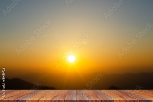 Wood table top on blur tropical scene of sunset or sunrise on the mountain in the summer with a yellow-blue sky background - can be used for display or montage your products. High quality photo
