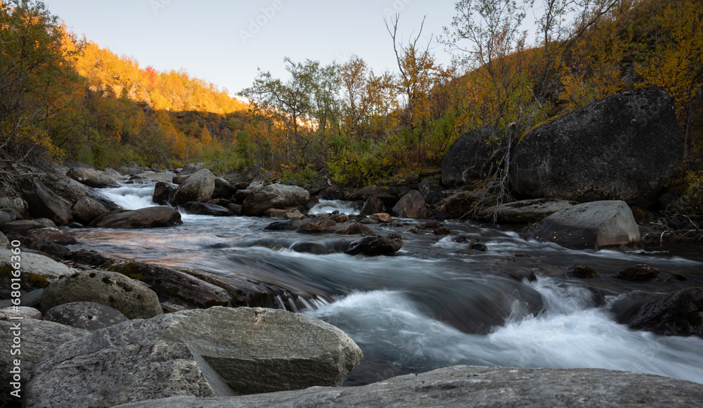 River flows in the vast landscape of Swedish Lapland on an autumn evening with surrounding autumn colors River flows in the vast landscape of Swedish Lapland on an autumn evening with surrounding autumn colors
