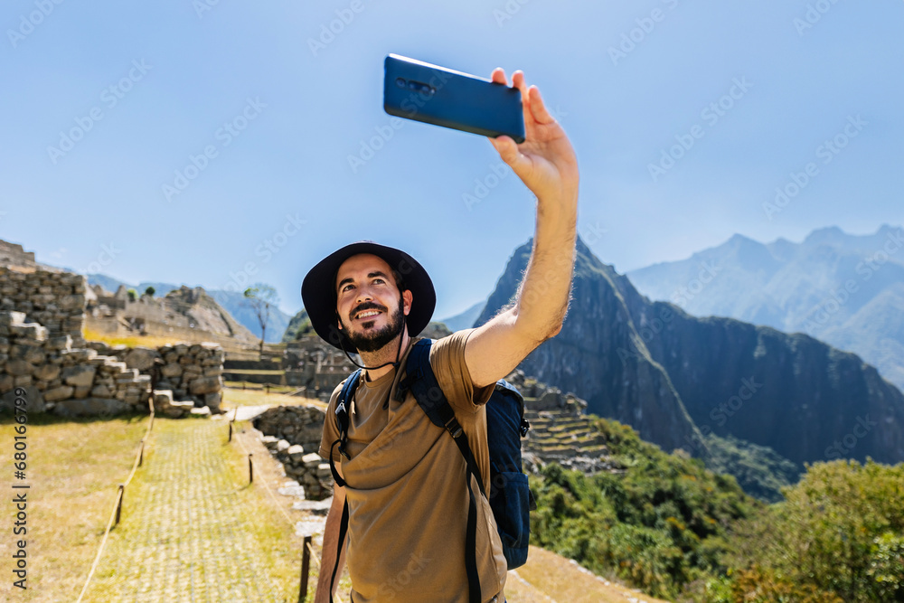 © Xavier Lorenzo - Young adult man taking selfie with phone camera at Machu Picchu. Joyful male tourist enjoying vacation in Peru, South America. Travel and vacation concept. © Xavier Lorenzo - Young adult man taking selfie with phone camera at Machu Picchu. Joyful male tourist enjoying vacation in Peru, South America. Travel and vacation concept.