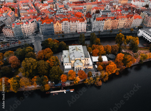 Aerial view of Slavonic Island in Prague - Czech republic during the autumn season on sunset. Top view of Park with colorful trees in Prague with cityscape of Old town on background.