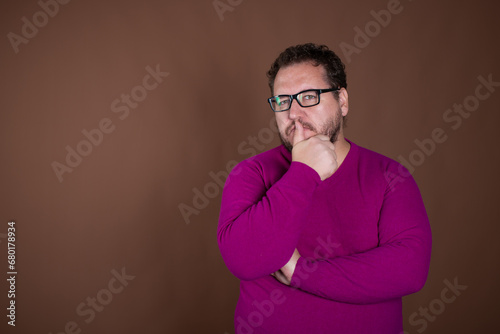 Funny fat man posing in studio on brown background. Different emotions. © vladorlov