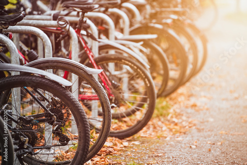 Bikes of different styles and colors lined up in a parking lot in the urban streets of a European destination for tourists and cyclists. photo