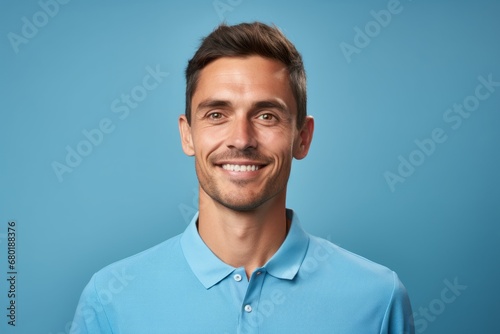 Portrait of a merry man in his 30s wearing a sporty polo shirt against a pastel blue background. AI Generation © CogniLens