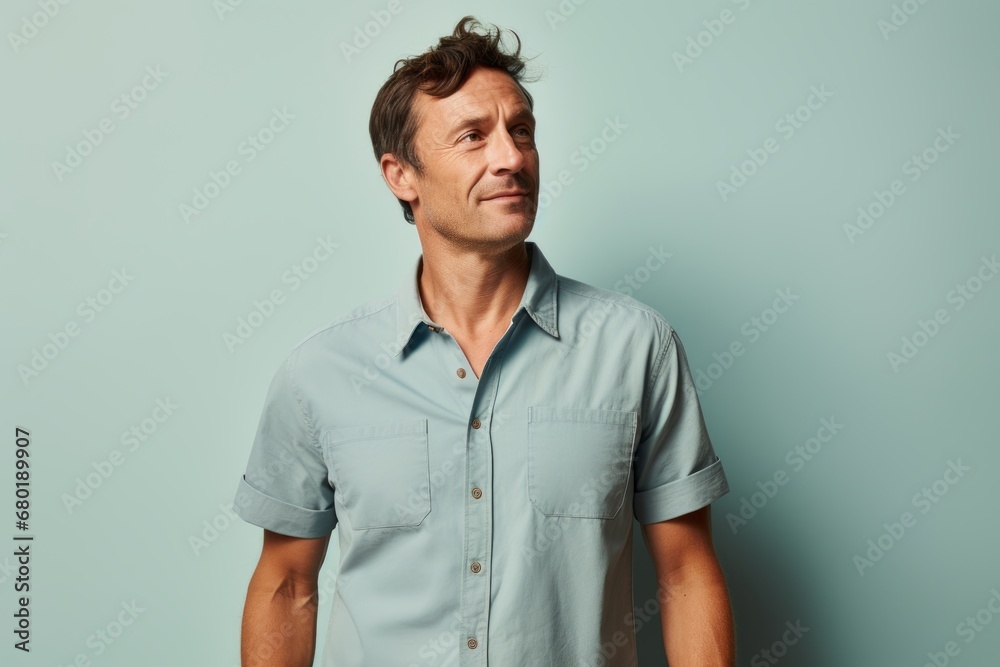 Portrait of a tender man in his 40s sporting a technical climbing shirt against a pastel blue background. AI Generation Portrait of a tender man in his 40s sporting a technical climbing shirt against a pastel blue background. AI Generation