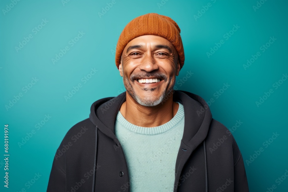 Portrait of a smiling man in his 50s sporting a trendy beanie against a pastel teal background. AI Generation Portrait of a smiling man in his 50s sporting a trendy beanie against a pastel teal background. AI Generation