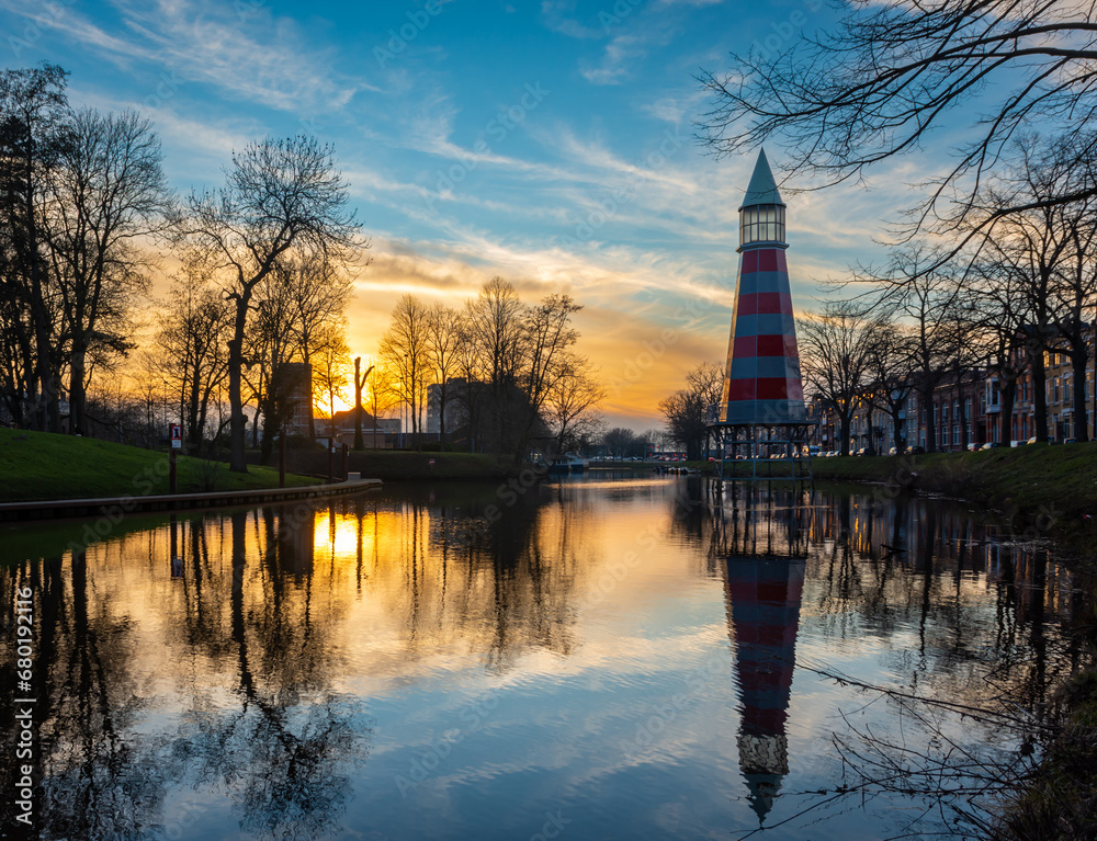 Fototapeta premium Lighthouse by sunset in dutch city of Breda mirrored in the water surface