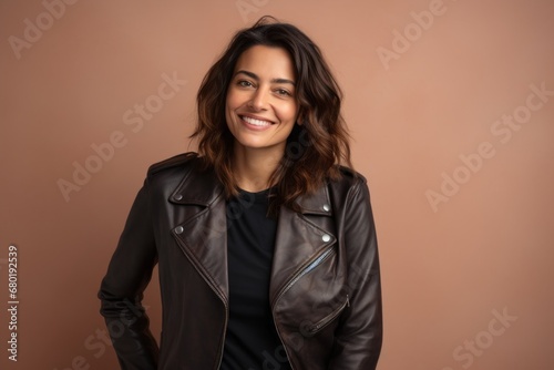 Portrait of a blissful woman in her 30s sporting a classic leather jacket against a pastel brown background. AI Generation