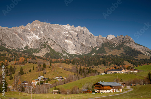 Beautiful panorama in the Austrian Alps in Salzburg near Dienten am Hochkönig. Mountain peaks, alpine pastures, farms, and a blue sky in autumnal mood.
