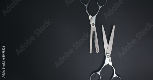 Hairdressing scissors on black background. Stylish Professional Barber Scissors. Tool care, scissor sharpening. photo