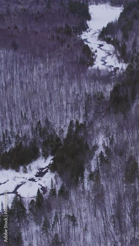 Aerial view of white winter river in the forest with  flowing water in Laurentides Canada (ID: 680200710)