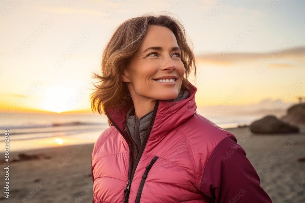 Portrait of a merry woman in her 40s sporting a quilted insulated jacket against a vibrant beach sunset background. AI Generation Portrait of a merry woman in her 40s sporting a quilted insulated jacket against a vibrant beach sunset background. AI Generation