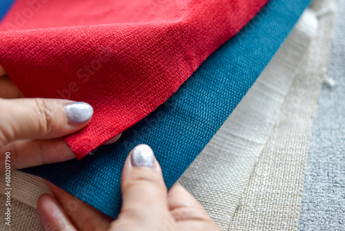 Close up view, Human hand selecting fabrics material samples for making furniture and home decorations