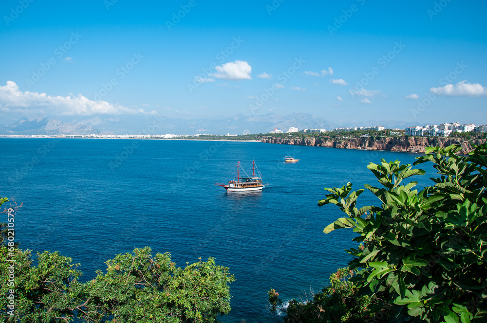 Obraz premium Antalya Kaleiçi tour boat, cliffs and Konyaaltı.