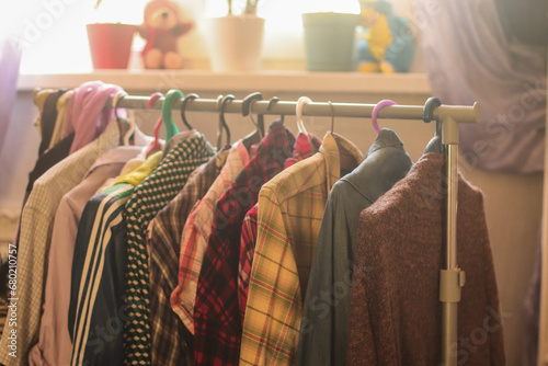 Clothes on hangers in a home. Second hand for swap. Concept of sustainable lifestyle and smart consumption photo