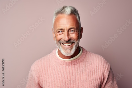 Portrait of a smiling man in his 50s wearing a cozy sweater against a pastel or soft colors background. AI Generation
