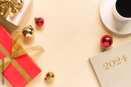 flat lay composition with gift boxes, gold ribbons, gold and red balls, cup of coffee and 2024 year planner. New Year background