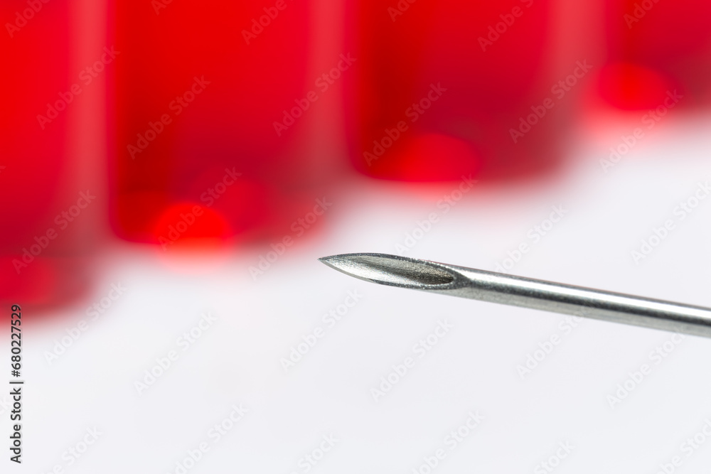 İnjection needle in selective focus, close-up. Injection ampoules of hormone B12 out of focus. İnjection needle in selective focus, close-up. Injection ampoules of hormone B12 out of focus.
