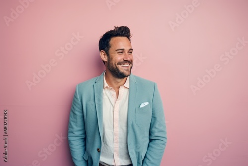 Portrait of a jovial man in his 30s wearing a chic cardigan against a solid pastel color wall. AI Generation