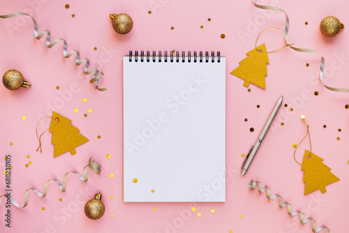 Christmas background with blank notebook, pen, silver stars and Christmas decoration. Space for text. Top view. Christmas to-do list or wish list